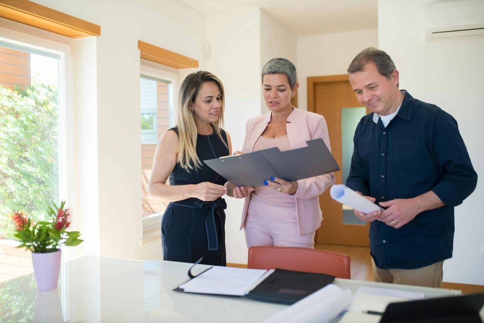 Real estate professional reviewing documents with clients