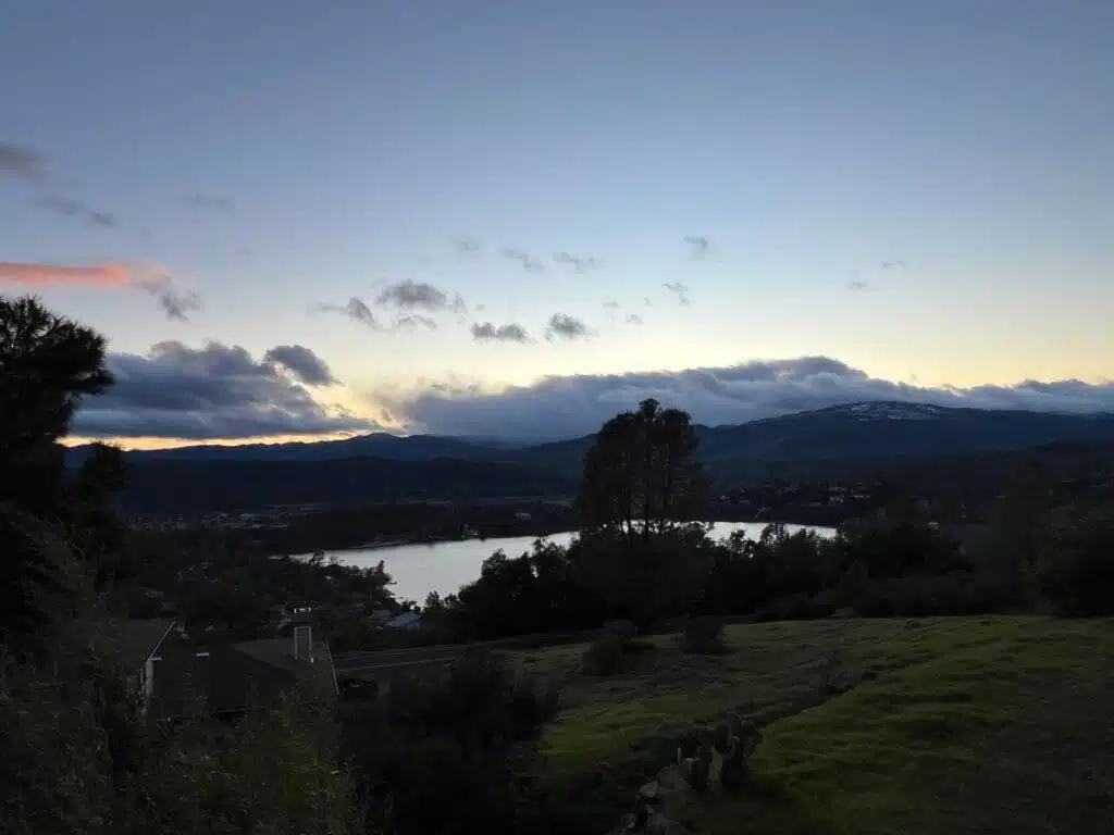 Cinematic view of a luxury USA house overlooking a pristine lake and mountains, representing premium American real estate and investment properties.