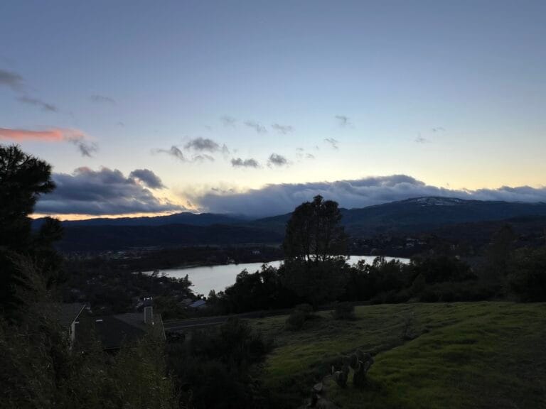 Cinematic view of a luxury USA house overlooking a pristine lake and mountains, representing premium American real estate for homebuyers to buy, sell or make an investment in the best properties. buy sell invest usa houses