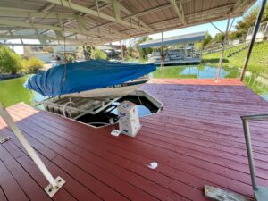 Boat slip with lift and dock that has covered parking spaces on Clear Lake canal