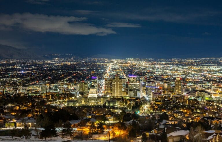 A breathtaking aerial view of Salt Lake City at night featuring a vibrant skyline and illuminated buildings.