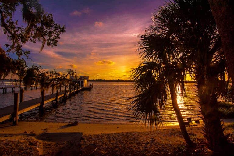 Capture the serene beauty of a Sarasota sunset reflecting over a calm ocean in Florida.