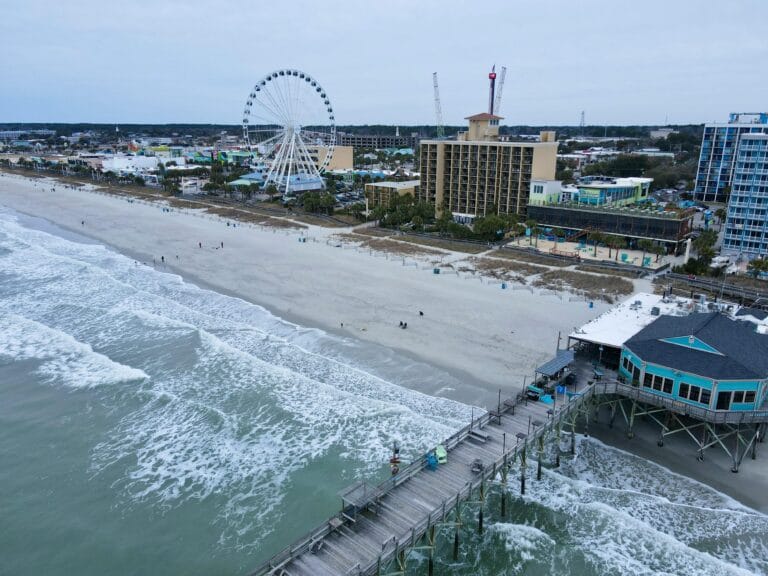 Aerial shot of Myrtle Beach South Carolina with iconic pier and ferris wheel, capturing coastal beauty.