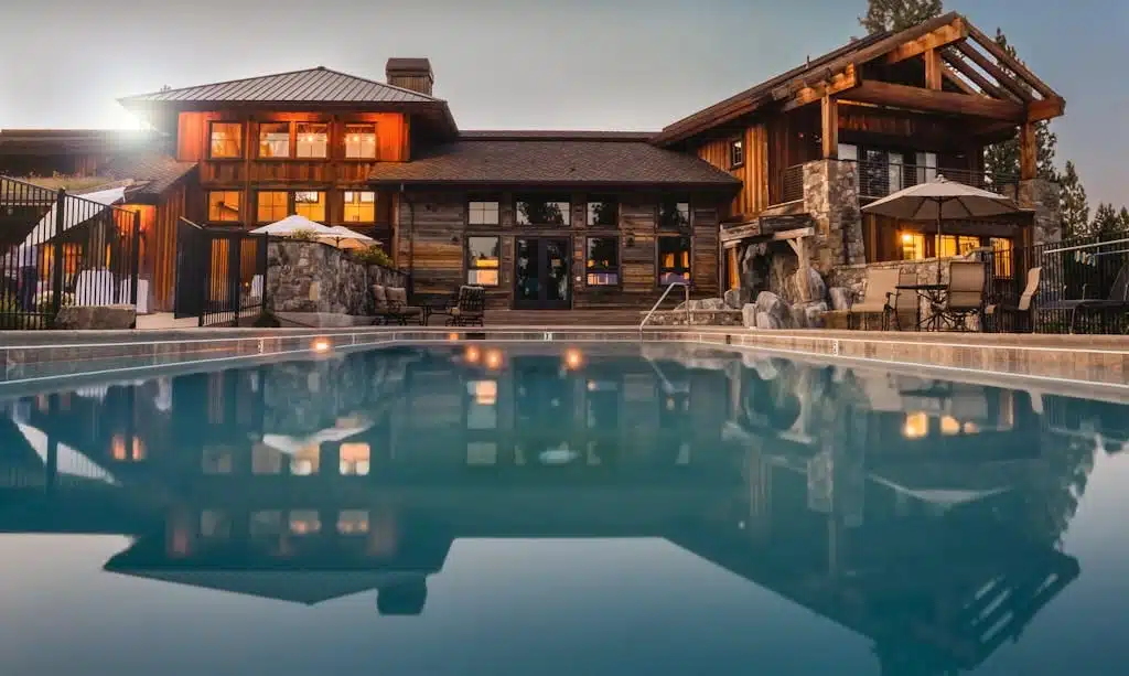 Stunning wooden villa with a large pool and cozy lights, perfect for a luxurious escape. USA Houses